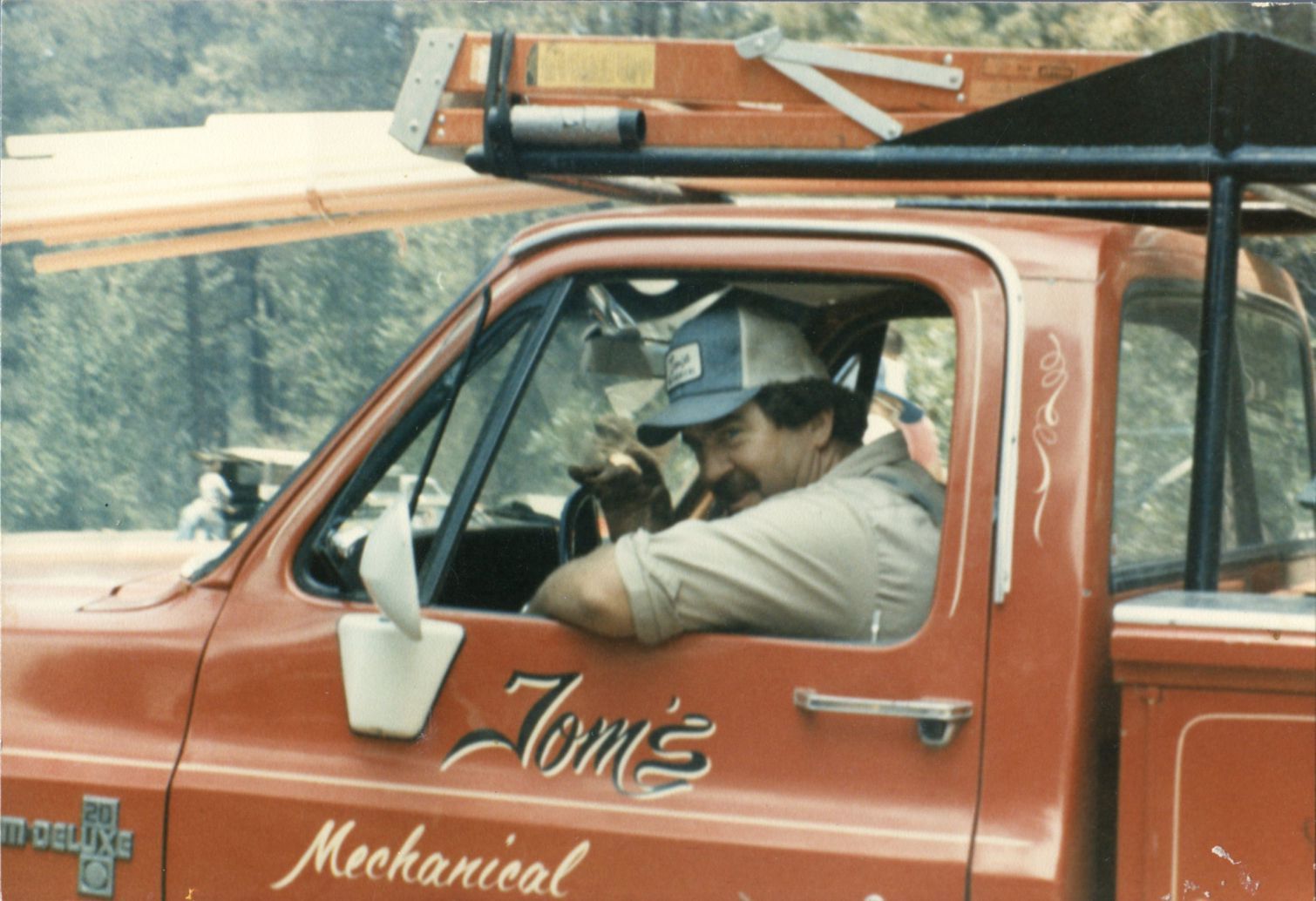 Tom Shakespeare in a red pickup looking out the window.